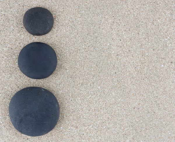 三个黑色的禅石在左边的沙背景