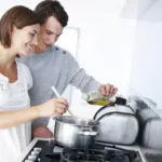一个快乐的年轻夫妇一起在厨房里准备一餐饭