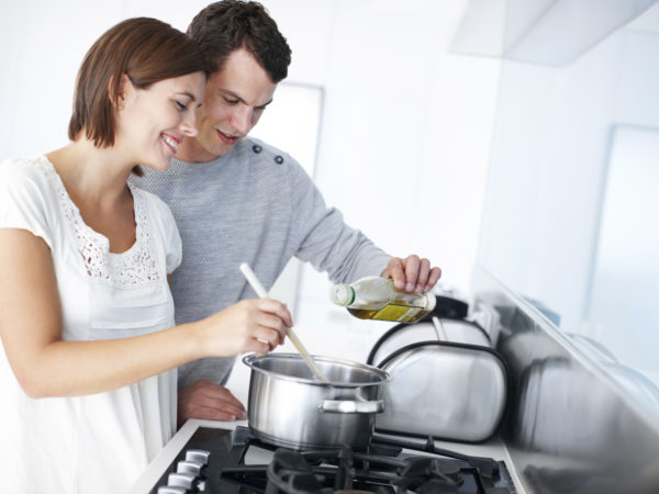 一对幸福的年轻夫妇在厨房里一起准备晚餐