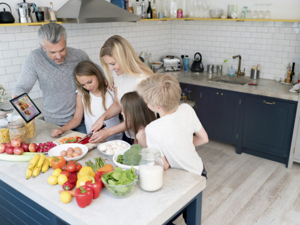 一家人在家里一起做晚餐，看起来很开心。平板上的设计是自己的设计。
