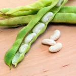 绿色豆荚白豆在木桌上特写。蔬菜、谷物。宏…