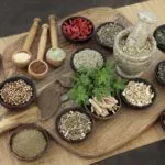 香草和香料的健康食品选择的男性在木碗和勺子。用于天然替代草药。
