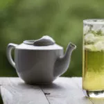 长长的绿色冰茶和玻璃茶壶在不聚焦的背景