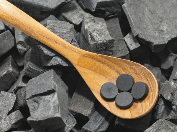 活性炭丸在木勺上木炭质地的背景