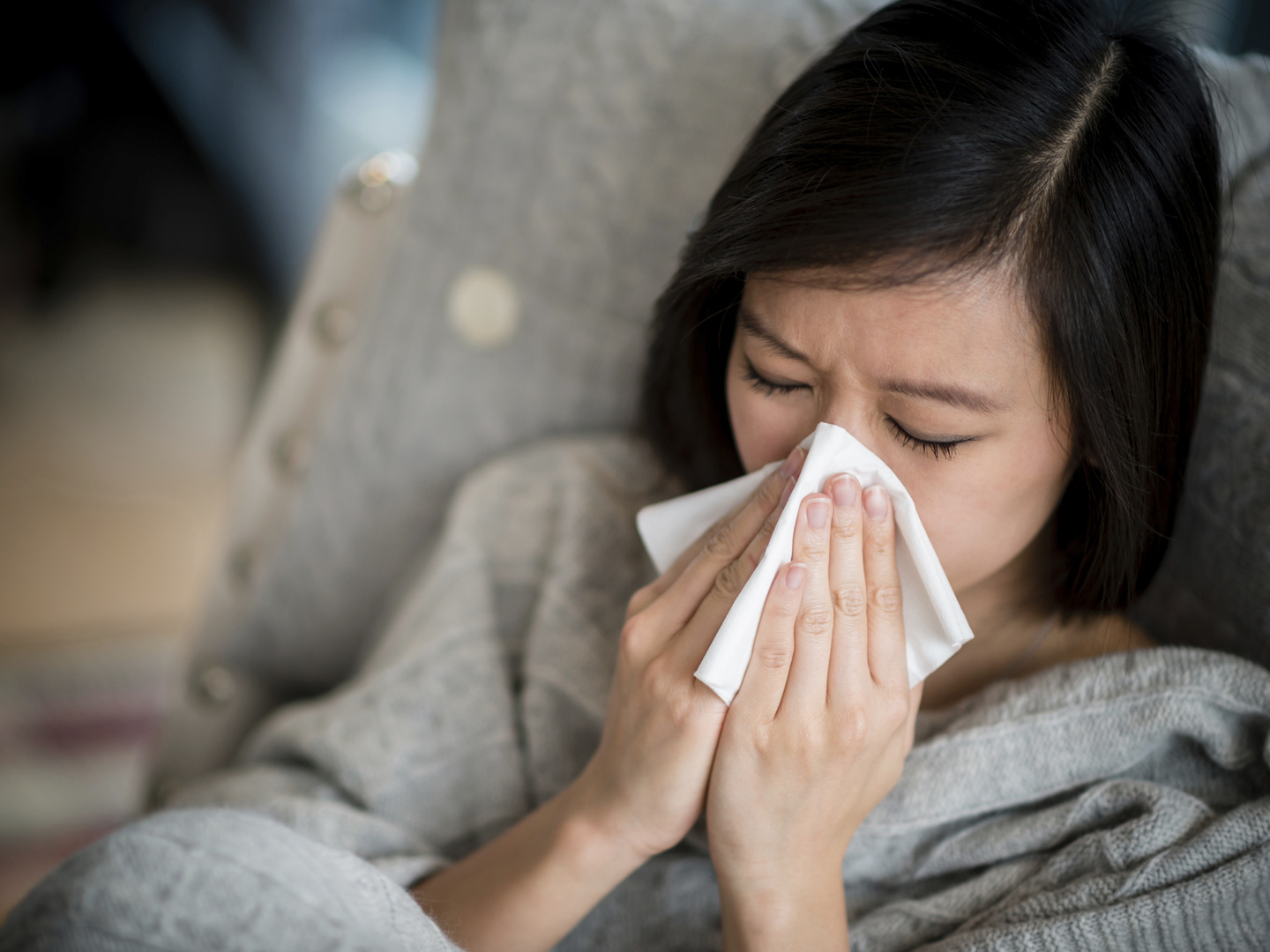 一个患流感的女人在擤鼻涕