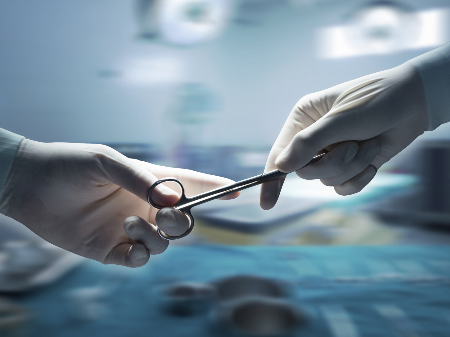 医疗保健和医疗概念，外科医生手拿手术剪刀和通过手术设备的特写，动态模糊背景。