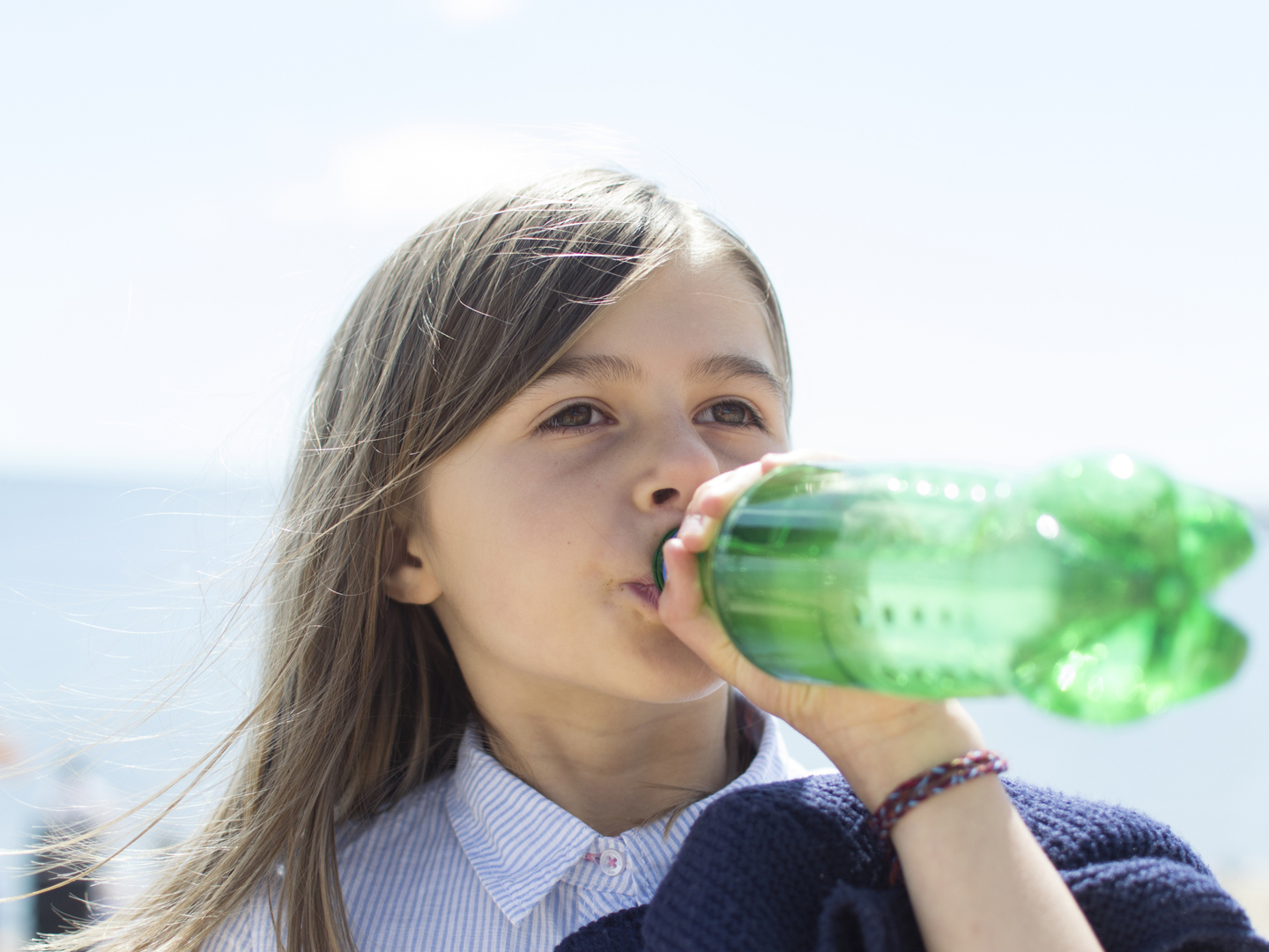一个孩子从塑料瓶里喝软饮料/汽水/苏打水