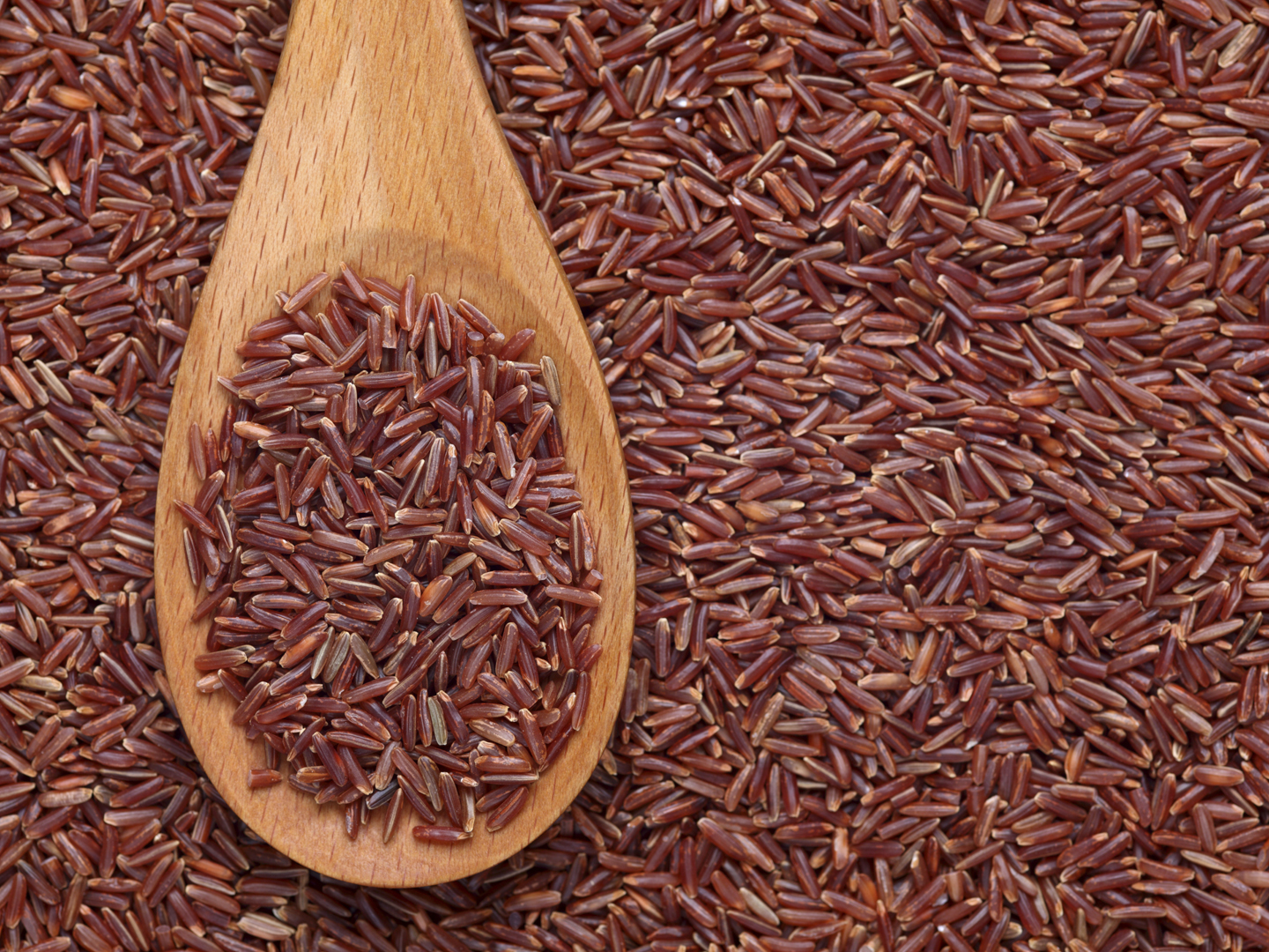 用木勺盛红米，放在红米的背景上。请参阅: