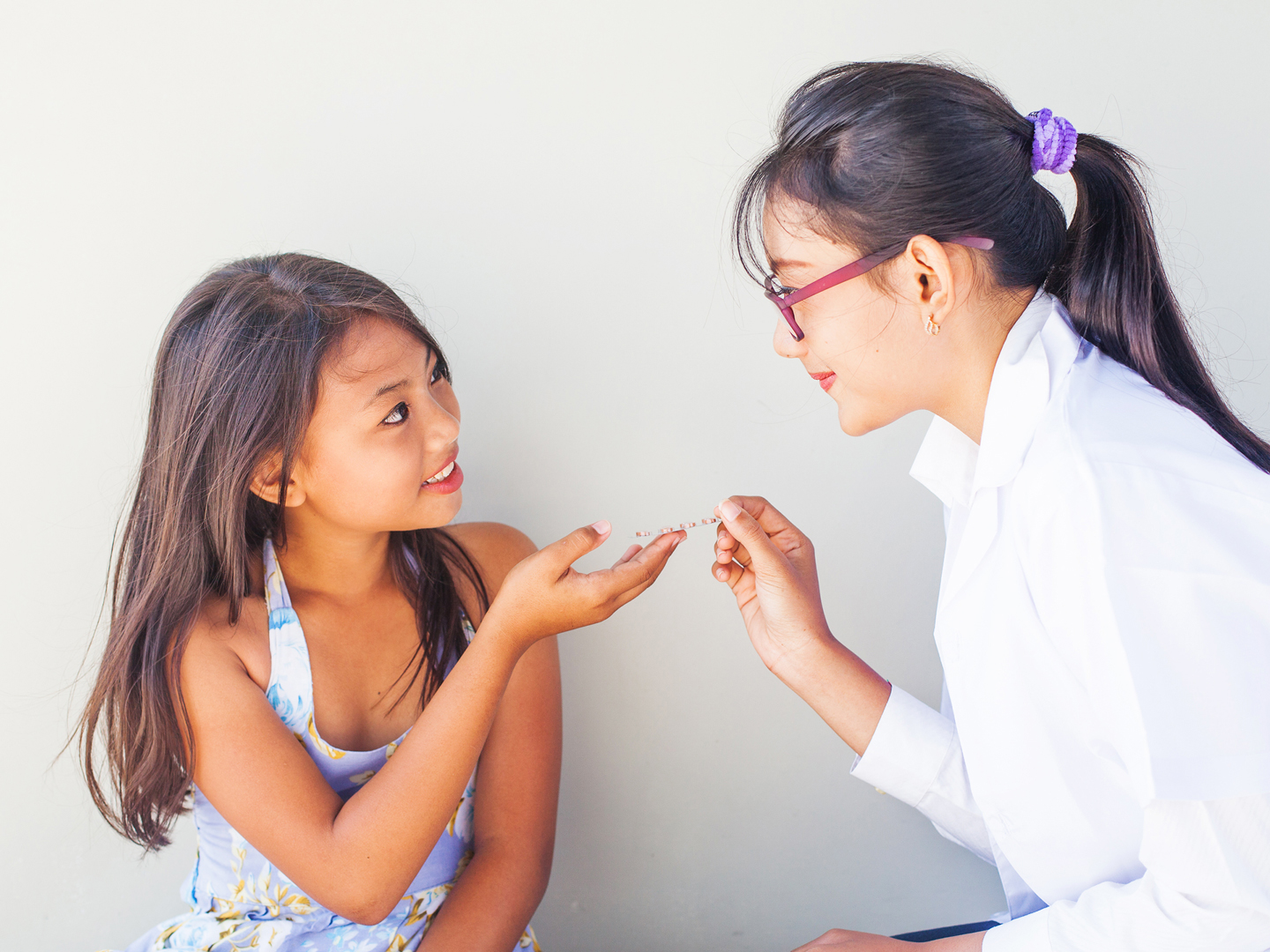亚裔年轻医生给亚裔小女孩吃药