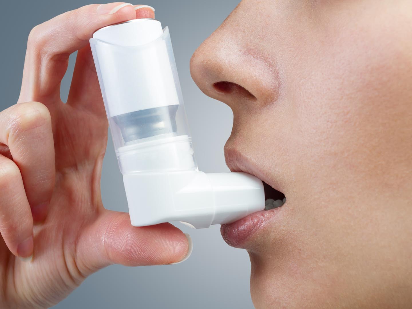 一名妇女在哮喘发作时使用吸入器，特写