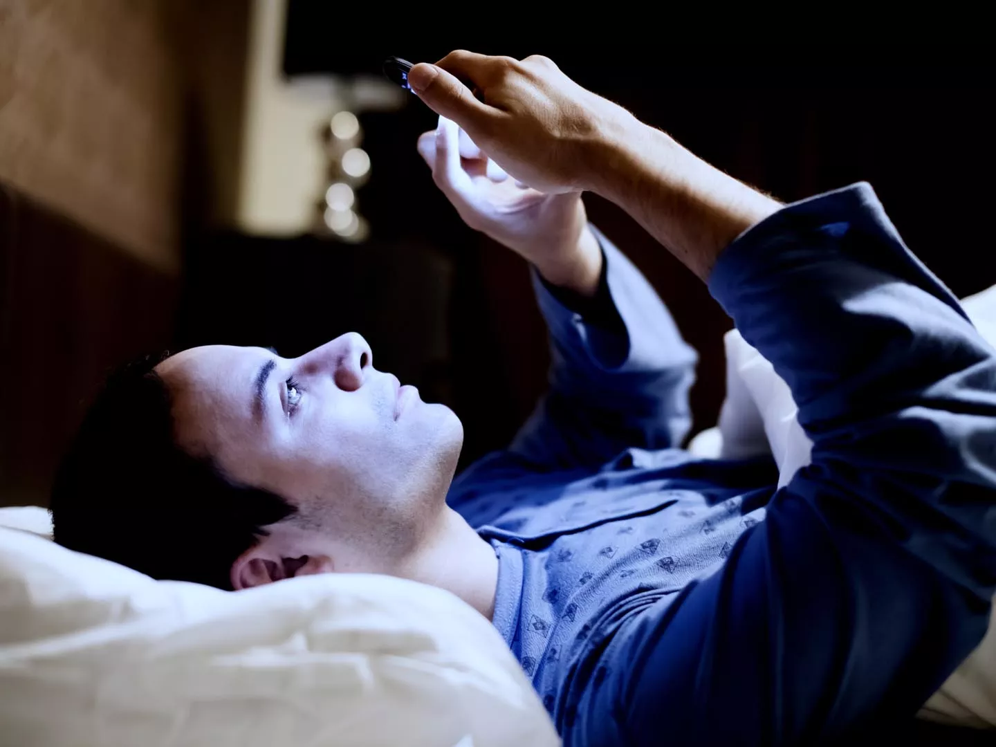 一个男人在床上用手机