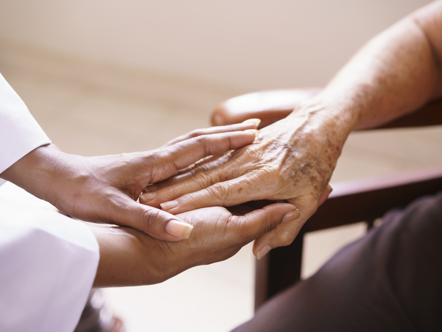 老年收容所的老人:老年病人接受一位黑人女医生的探视。他们在医院里握手交谈。