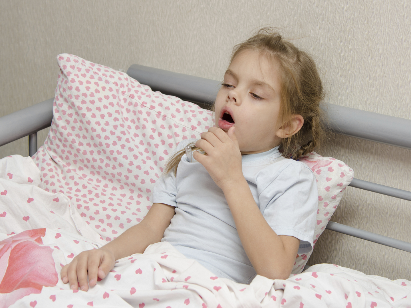 六岁的小女孩咳嗽患病躺在床上用温度计对着老鼠