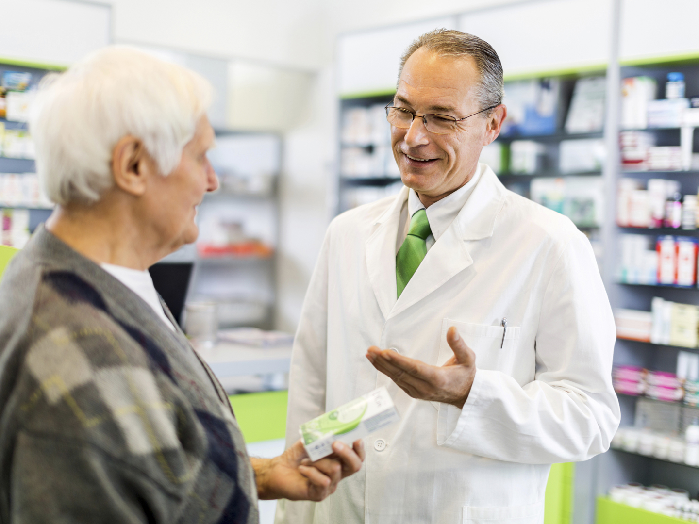 在药店里，成熟的药剂师和年长的男人交谈。