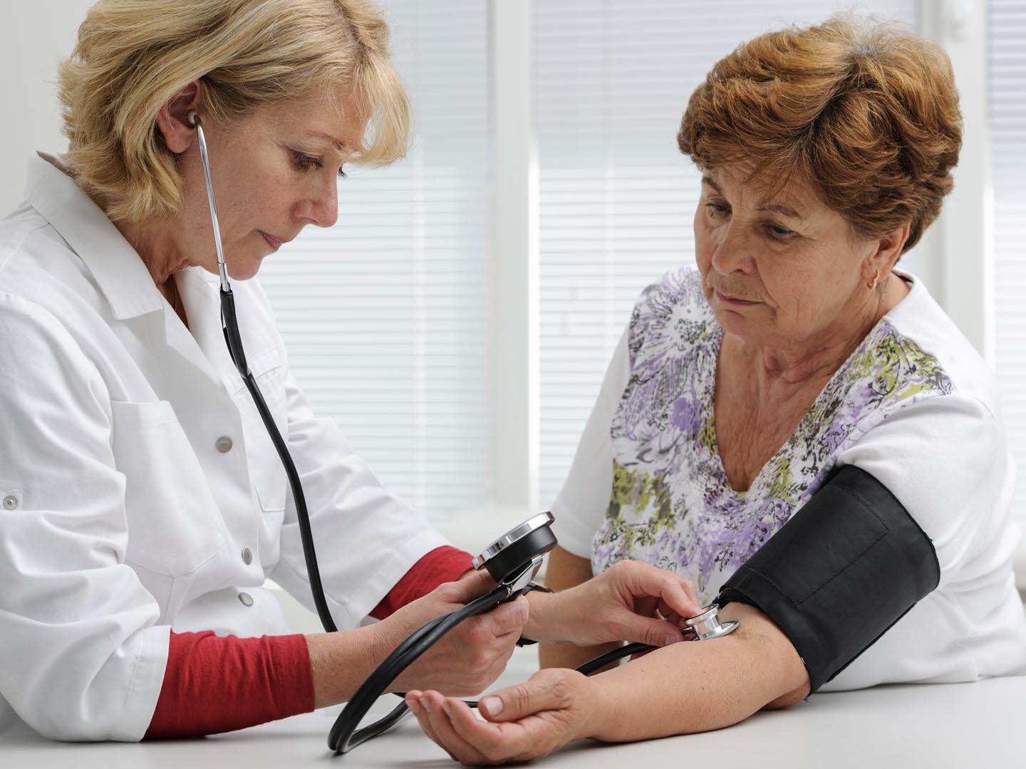 医生为女性患者测量血压