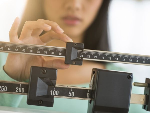 中年亚洲女性腹部调整平衡体重秤